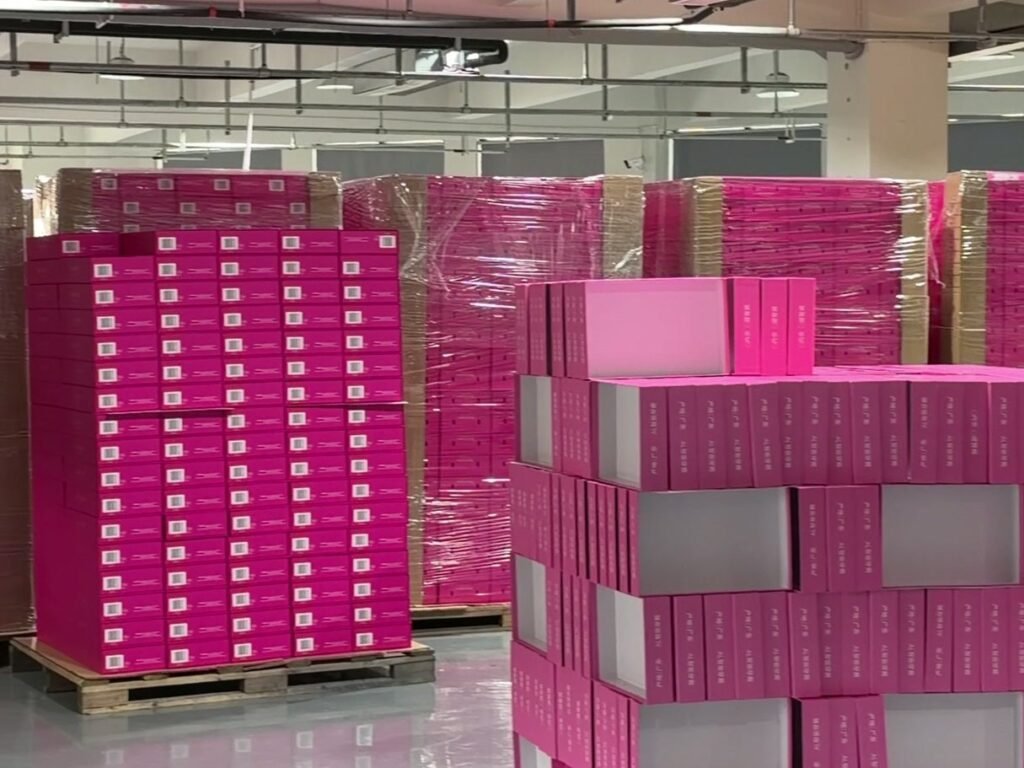 Finished pink boxes stacked on pallets in the workshop