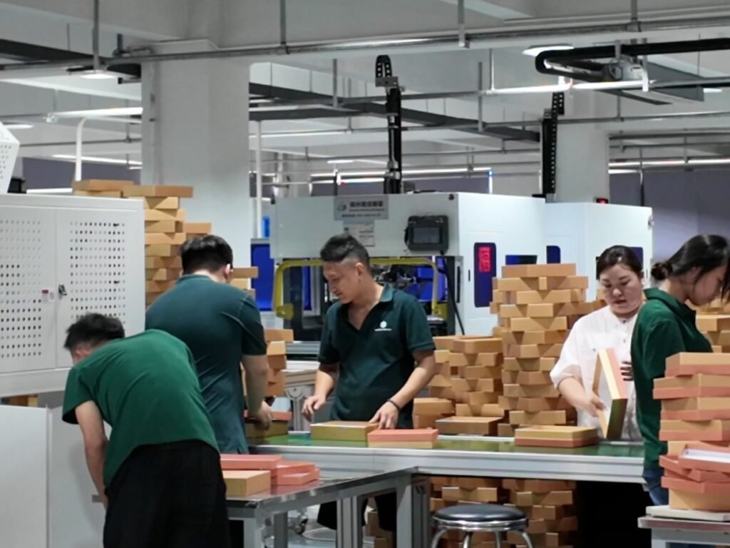 Workers finishing gift boxes by hand on the production line