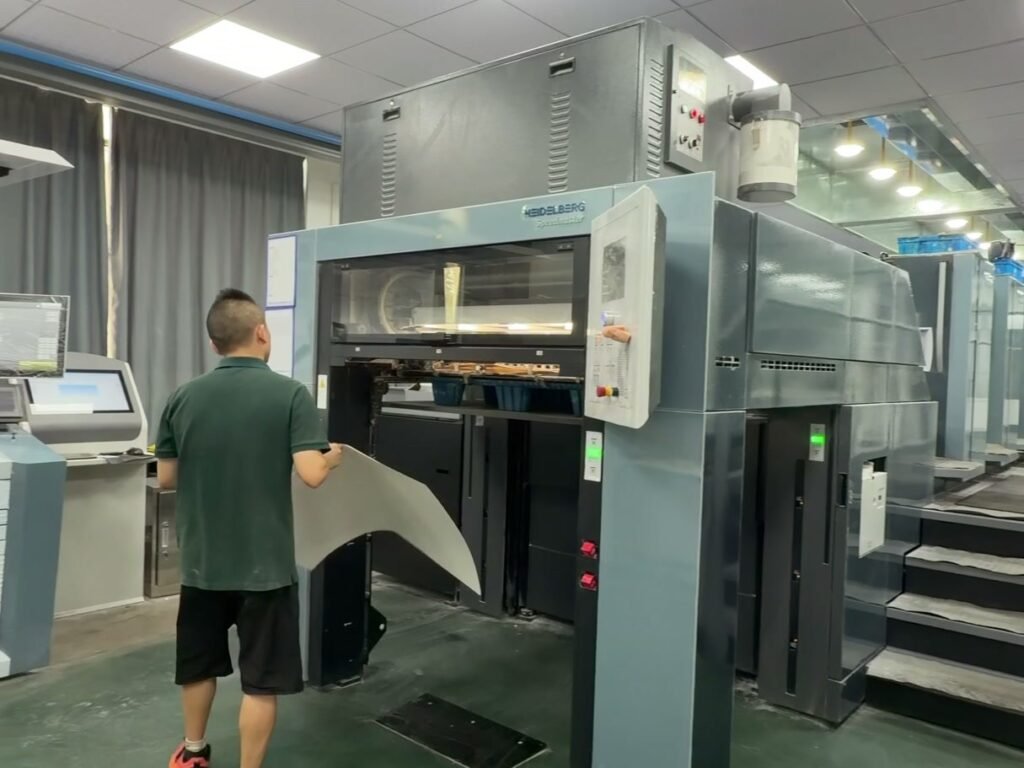 Operator checking a printed sheet at the offset printing press